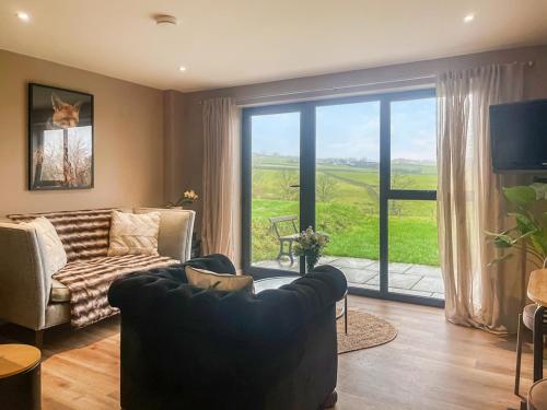 a living room with a couch and a sliding glass door at The Foxes Hole - Uk49085 in Winewall