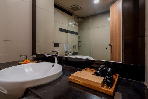 a bathroom with a sink and a large mirror at Tusita Boutique Hotel in Kuta