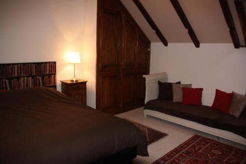 a bedroom with a bed and a couch in it at La Grange de Jeanne in Moosch