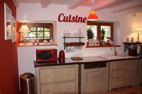 a kitchen with a sink and a microwave on a counter at La Grange de Jeanne in Moosch