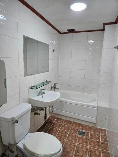 a bathroom with a toilet and a sink and a tub at 부천역 감성 숙소 in Samgong