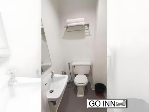 a white bathroom with a toilet and a sink at xx GO INN Phuket Old Town in Phuket