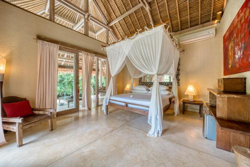 a bedroom with a bed with a canopy at Nomadic Resort Bali in Canggu