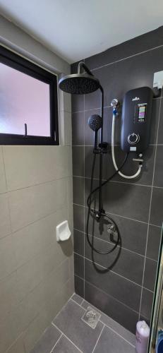 a shower with a shower head in a bathroom at Setia Alam Homestay - Quiet High-Floor Studio in Shah Alam