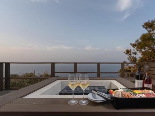 a table with two glasses of wine and a tray of food at The THERM in Munakata