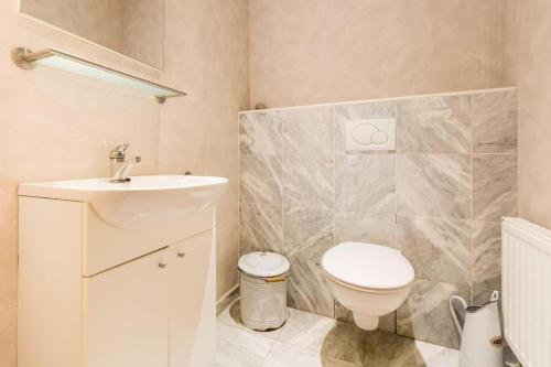 a bathroom with a white toilet and a sink at De Notelaar in Alveringem