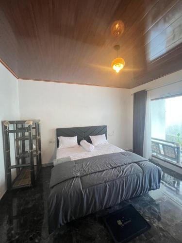 a bedroom with a bed and a large window at Andre Homestay in Kuta Lombok