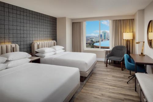 a hotel room with two beds and a desk at Hyatt Regency Wichita in Wichita