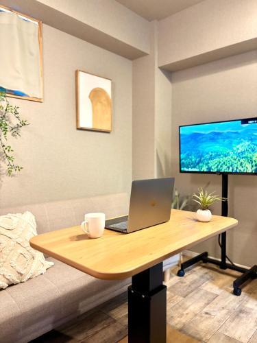 a laptop on a table in a living room with a couch at Hal Kokubunji in Kokubunji