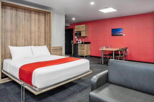 a bedroom with a bed and a chair and a table at Quality Suites in Drummondville