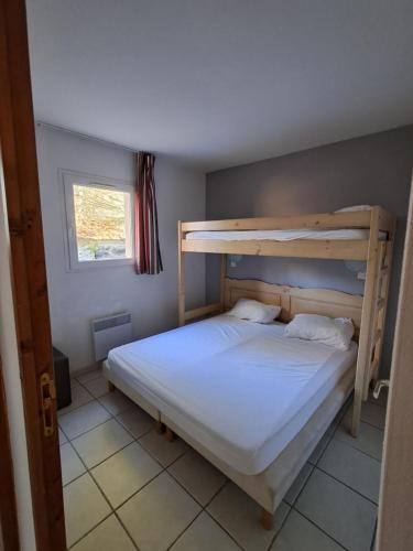 a bedroom with a bunk bed and a window at Appartement dans résidences de vacances in Salavas