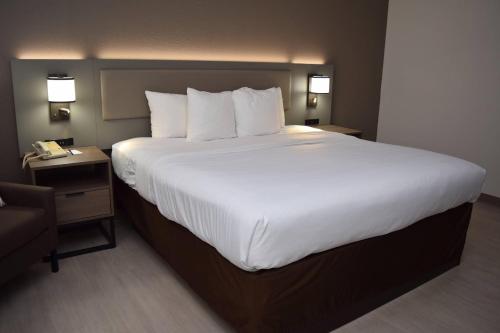 a large bed with white sheets and pillows in a hotel room at Comfort Inn & Suites Syracuse-Carrier Circle in Syracuse