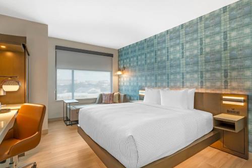 a hotel room with a large bed and a desk at Cambria Hotel Fort Worth - Medical Center in Fort Worth