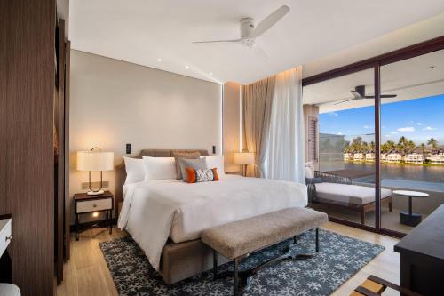 a bedroom with a large bed and a balcony at Angsana Oceanview Residences Building 2 in Laguna by Banyan Living in Bang Tao Beach