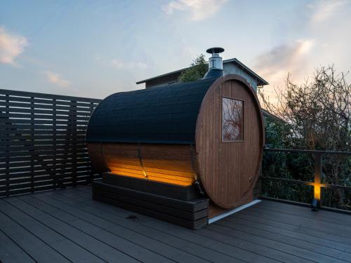 a small wooden hobbit house on a deck at The THERM in Munakata