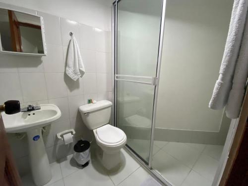 a bathroom with a shower and a toilet and a sink at Hotel Tariq Monteria in Montería