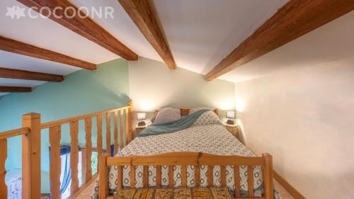 a bedroom with a crib in a room with wooden ceilings at CHEZ BETTY in Le Luc