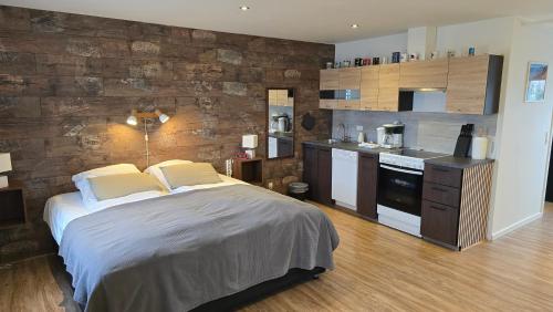 a bedroom with a large bed and a kitchen at Vestbjerg Apartments in Vestbjerg