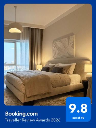a bedroom with a large bed and a large window at Signature Studio JLT in Dubai