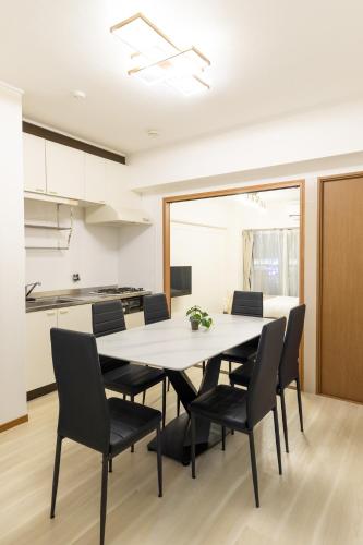 a kitchen and dining room with a table and chairs at Roots Osaka Station 2 in Osaka