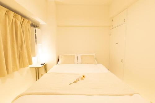 two beds in a white room with a bird on the bed at Roots Osaka Station 2 in Osaka