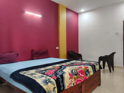 a bedroom with a bed with a colorful wall at R K Guest House Arpora in Mapusa