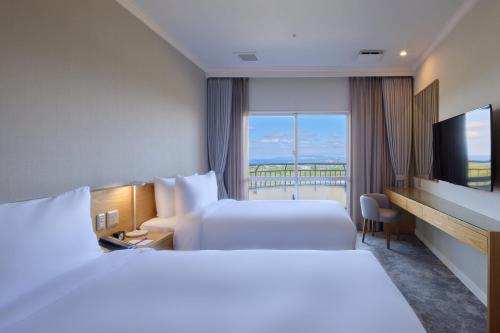 a hotel room with two beds and a window at ANA Crowne Plaza Resort Okinawa Uruma Hills By IHG in Uruma