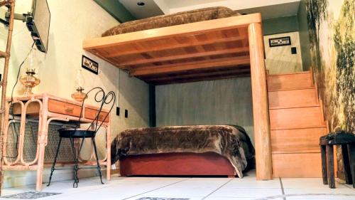 a bedroom with a wooden bed and a staircase at Hotel Coyoacan in Mexico City