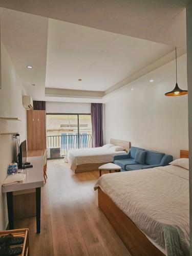 a hotel room with two beds and a blue couch at SAIGON GARDEN HILL Resort & Apartment in Ho Chi Minh City