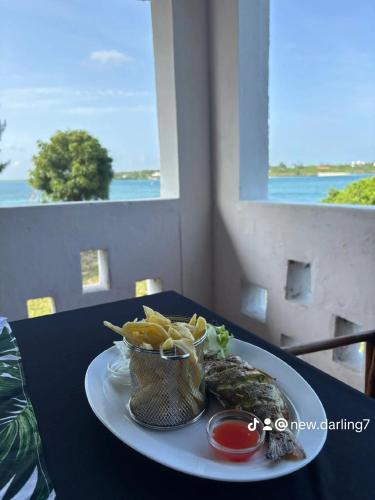 a plate of food with fish and chips on a table at Newdarling beach hotel in Watamu