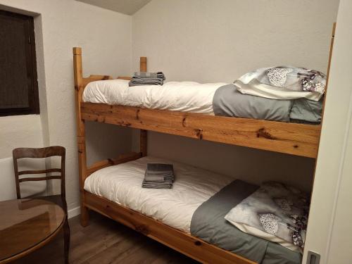 two bunk beds in a room with a table at Valmalenco Home in Chiesa in Valmalenco