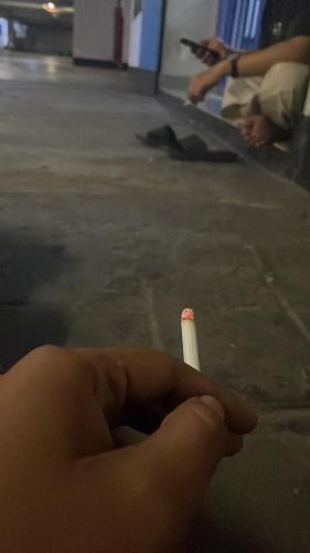 a person holding a cigarette in their hand at Malu dahlia in Jakarta