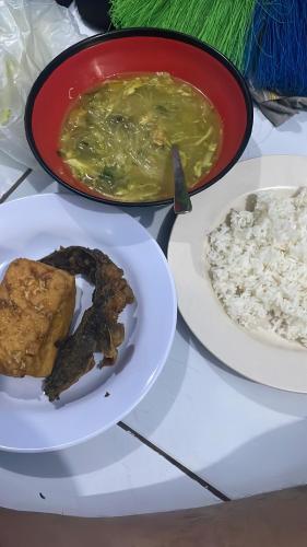 a table with two plates of food and a bowl of rice at Malu dahlia in Jakarta