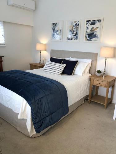 a bedroom with a large bed with blue and white pillows at Hills Manor House in Greenmount