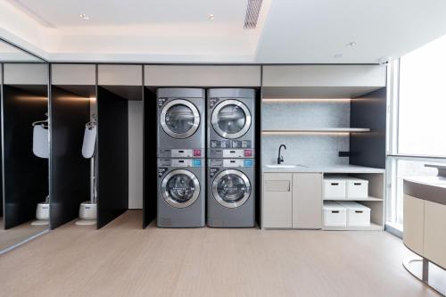 a laundry room with three washing machines and a sink at JI Hotel Suzhou Wujiang Development Zone in Suzhou