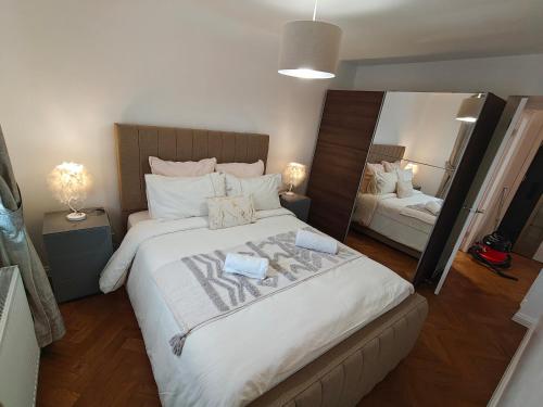 a bedroom with a large bed with a large mirror at Lovely 2 Bedroom Modern Ground Floor Flat in Clydebank