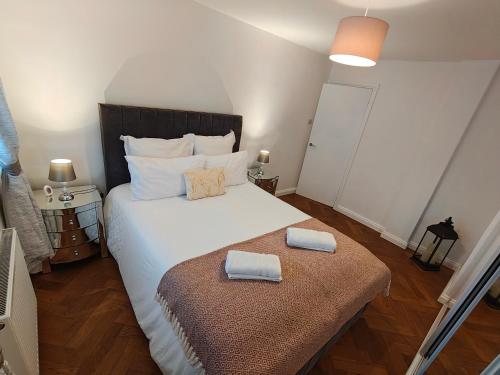 a bedroom with a large bed with two pillows on it at Lovely 2 Bedroom Modern Ground Floor Flat in Clydebank