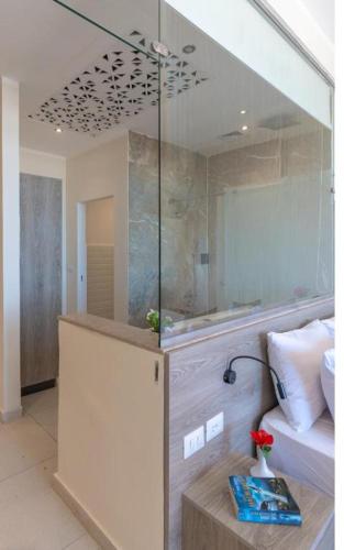 a room with a shower with a bed and a table at Three Corners Equinox Beach Resort in Abu Dabbab