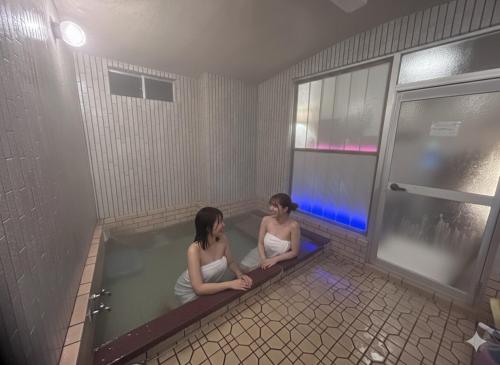 two women sitting in a bathtub in a building at Ryoso Chatani in Kyoto