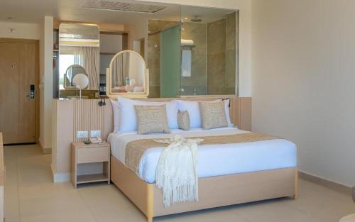 a bedroom with a large bed with a large mirror at Three Corners Equinox Beach Resort in Abu Dabbab
