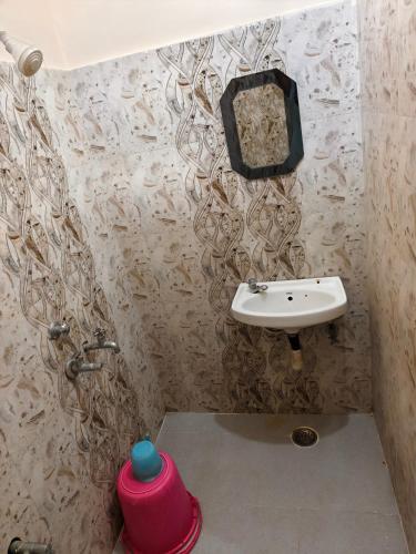 a small bathroom with a sink and a sink at Hotel Vijay in Rājgīr