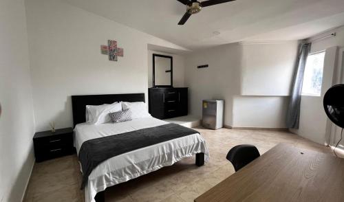 a bedroom with a bed and a table in it at Hotel Tariq Monteria in Montería