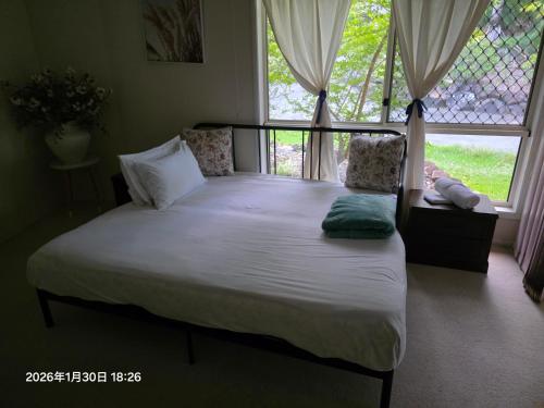 a large bed in a bedroom with a window at Gaven Garden in Gold Coast