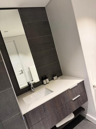 a bathroom with a sink and a mirror at Enzo Stay -The Matrix 505 , Century City in Cape Town