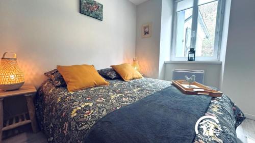 a bedroom with a bed and a table and a window at Le moulin de camelière in Caudebronde