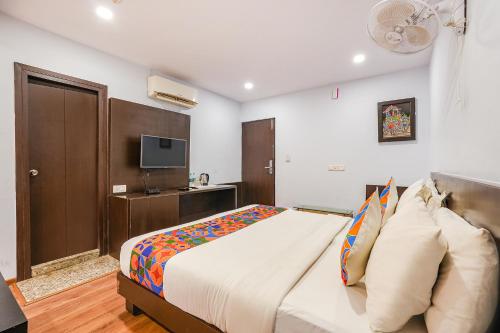 a bedroom with a large bed and a tv at FabHotel Upstream Mysore Road in Bangalore