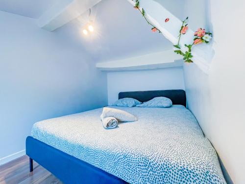 une chambre bleue avec un lit et un arrangement floral au plafond dans l'établissement Charmant duplex, à Clermont-Ferrand