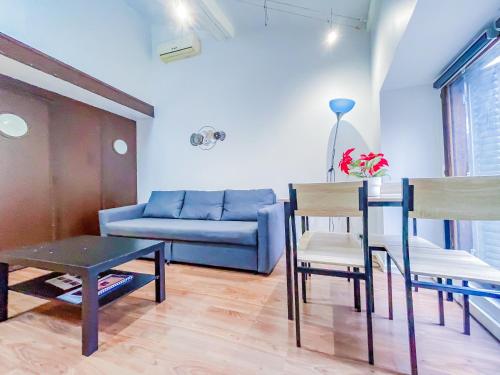 un salon avec un canapé bleu, une table et des chaises dans l'établissement Charmant duplex, à Clermont-Ferrand