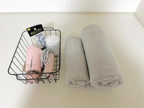 a basket with towels and other items on a shelf at Bon House Tokyo Private Luxury Retreat with Free Parking Reservation Required in Tokyo