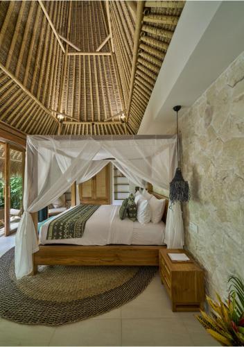 a bedroom with a bed with a canopy at ARYA Sumba - Kodi Resort in Tambolaka